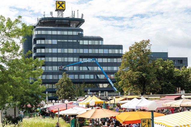 Slide Lkw-Bühne bei Reigingunsarbeiten an einer großen Fassade im Einsatz